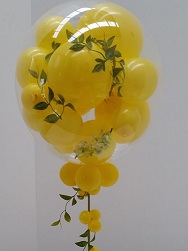 Colourful celebrations with bobo balloon stuffed with yellow balloons and leaves