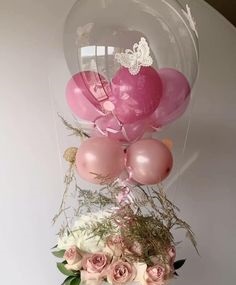 2 pink balloons inside a hot air balloon with 3 pink balloons on the stick tied to 12 Pink and white roses basket